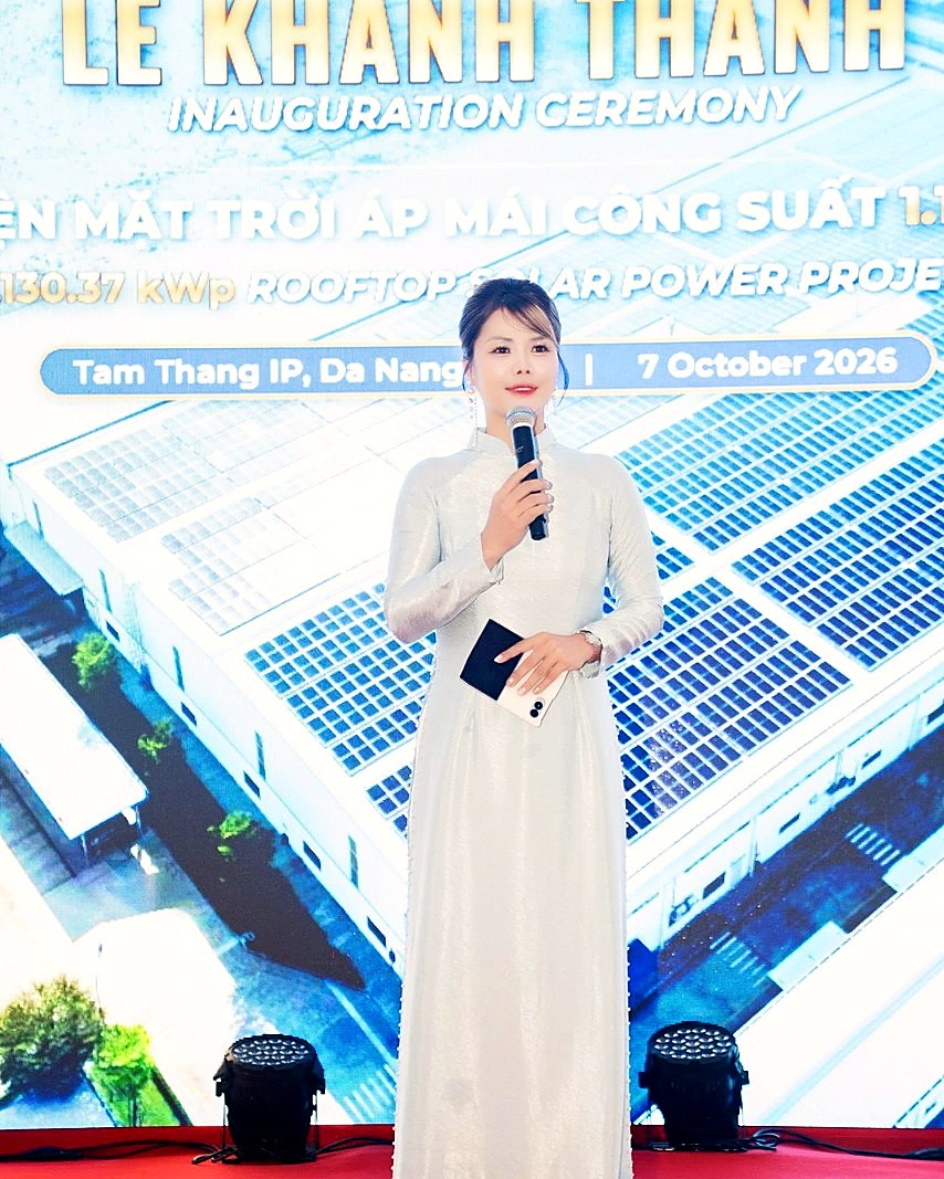 身穿白色奧黛在舞台上主持的明秋